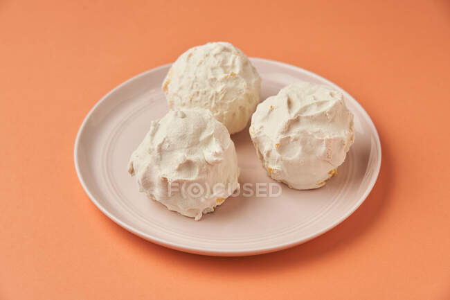 From above sweet balls placed on ceramic plate on orange background — Stock Photo