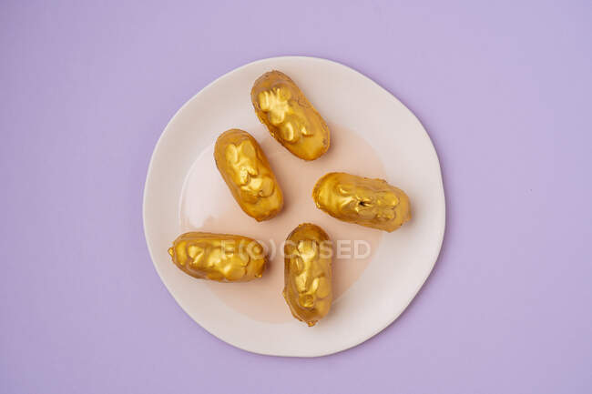 Eclares saborosos com glacê dourado — Fotografia de Stock