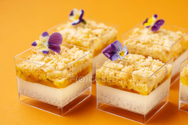 Контейнери зі смачним десертом, прикрашені квітами — стокове фото
