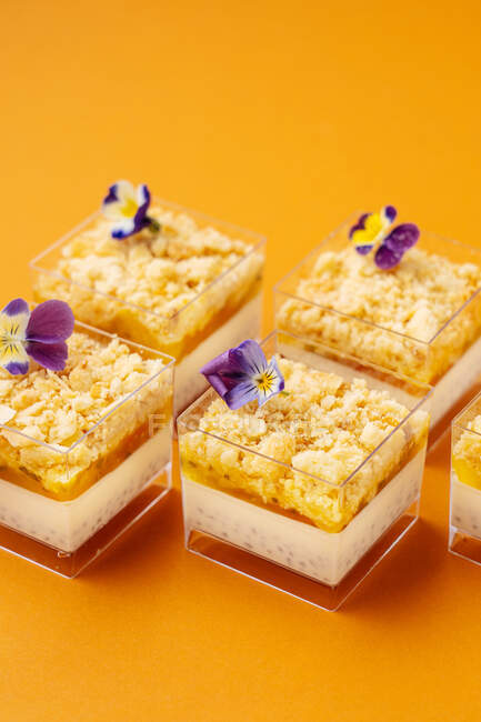 Gefäße mit leckerem Dessert mit Blumen dekoriert — Stockfoto