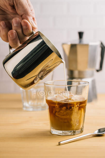 Irreconocible barista vaso de café con leche - foto de stock