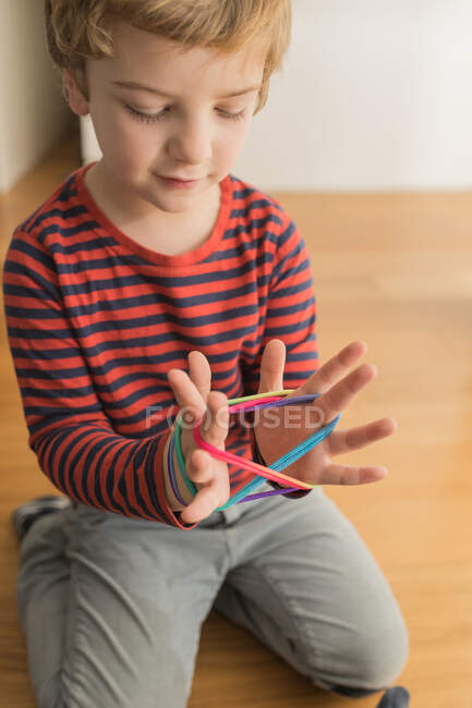 Smart kid using rubber bands for game — Stock Photo