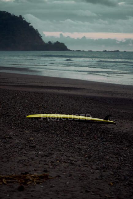 Picturesque scenery of surfboard on sandy beach in twilight in Costa Rica — Stock Photo