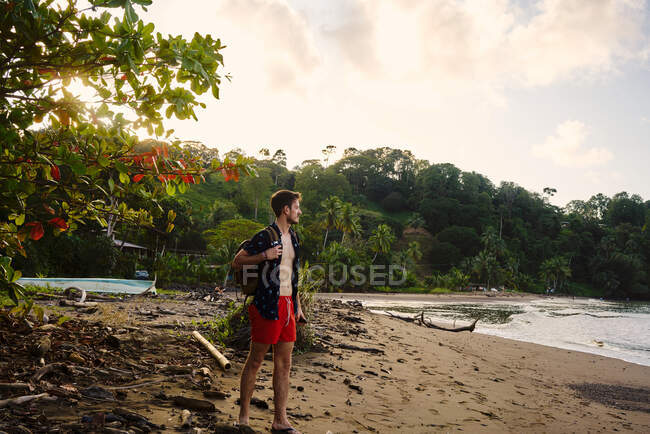 Konzentrierte junge männliche Reisende genießen das Meer, während sie an der Sandküste Costa Ricas stehen — Stockfoto