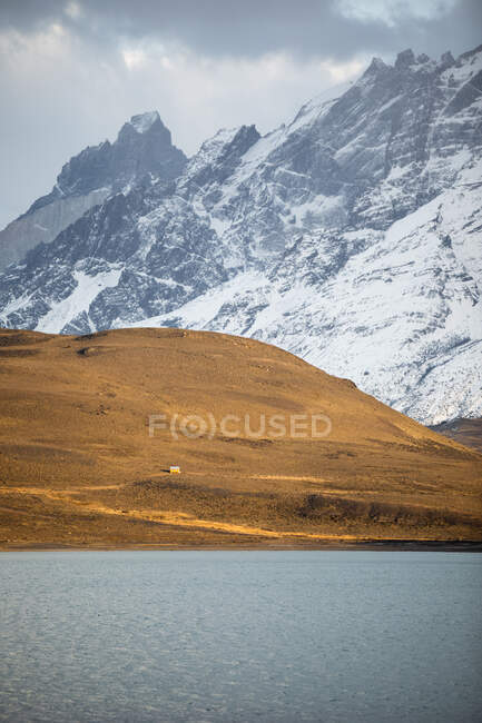 Beautiful scenery of river in valley against foggy snowy mountains — Stock Photo
