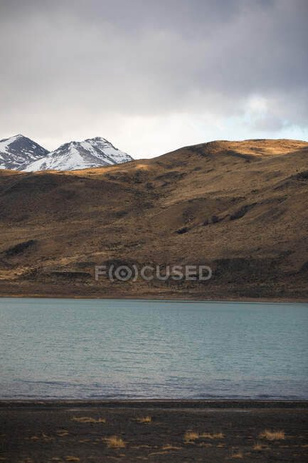 Schöne Flusslandschaft im Tal vor nebligen, schneebedeckten Bergen — Stockfoto