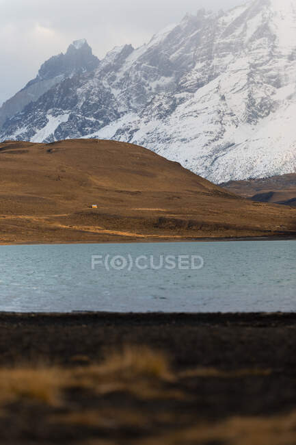 Schöne Flusslandschaft im Tal vor nebligen, schneebedeckten Bergen — Stockfoto