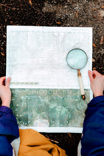 Escursionista irriconoscibile che naviga con mappa e bussola in campagna — Foto stock