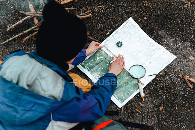 Escursionista irriconoscibile che naviga con mappa e bussola in campagna — Foto stock