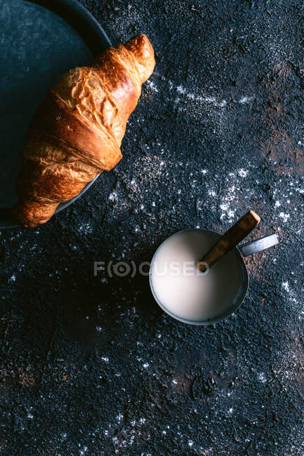Croissant und Milch auf dem Tisch — Stockfoto