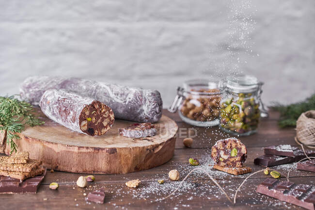 Chocolate salami with nuts on wooden table — Stock Photo