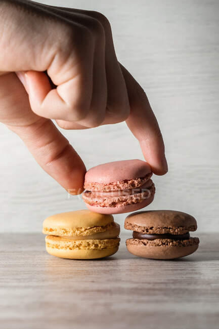 Crop hand placing macaroons on the table — Stock Photo