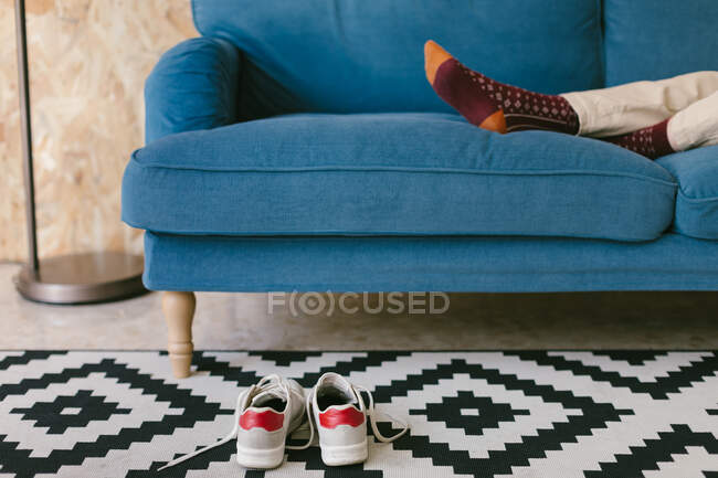 Ernteunternehmerin mit Schuhen zum Chillen auf blauem Sofa in der Pause — Stockfoto