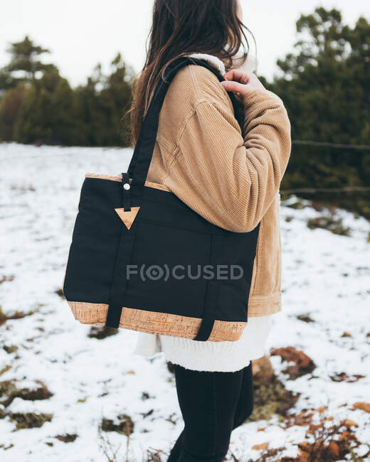 Young woman in trendy outfit walking in winter forest — Stock Photo