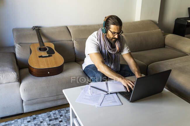 Окаменевший мужчина работает с ноутбуком в гостиной — стоковое фото