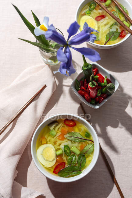 From above top view oriental ramen healthy noodles soup with shiitake, spinach, carrots, eggs and chillies on restaurant table — Stock Photo