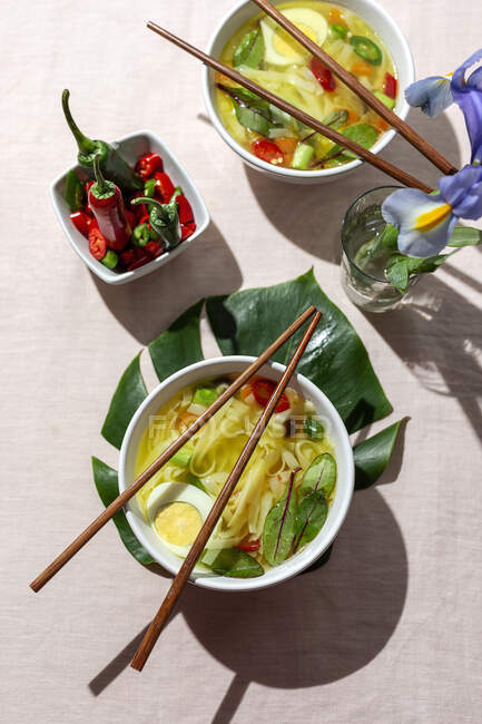 De dessus vue ramen oriental nouilles saines soupe avec shiitake, épinards, carottes, œufs et piments sur la table du restaurant — Photo de stock