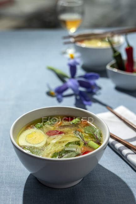 Dall'alto ramen orientale zuppa di tagliatelle sane con shiitake, spinaci, carote, uova e peperoncini sul tavolo del ristorante — Foto stock
