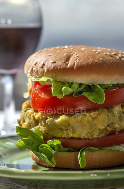 Hamburguesa de lenteja verde vegana sana casera con tomate, lechuga y papas fritas - foto de stock