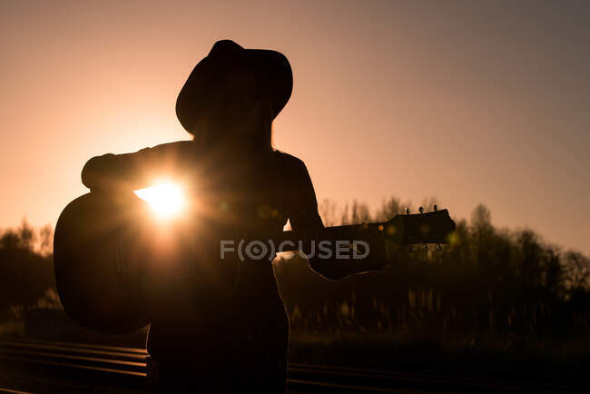 Woman playing guitar on rails — Stock Photo