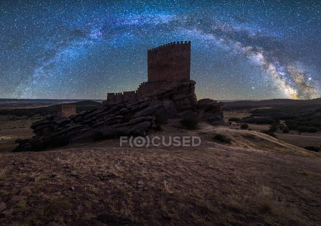 Restos de castelo antigo sob Via Láctea na noite estrelada com luz lanterna — Fotografia de Stock