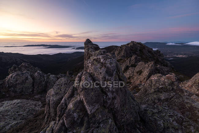 Von oben raue mächtige Gipfel der Klippen mit Meeresküste und buntem Abendhimmel im Hintergrund — Stockfoto