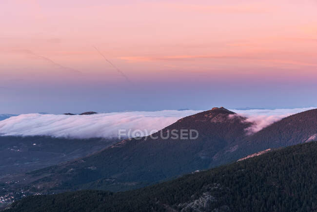 Von oben über der Altstadt am Hang des Hügels inmitten grüner Wälder mit dichtem Nebel unter buntem Morgenhimmel — Stockfoto