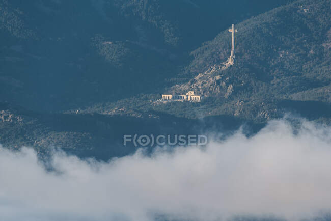 Dall'alto di centro storico su pendio di collina tra foresta verde coperta da nebbia densa sotto cielo colorato del mattino — Foto stock