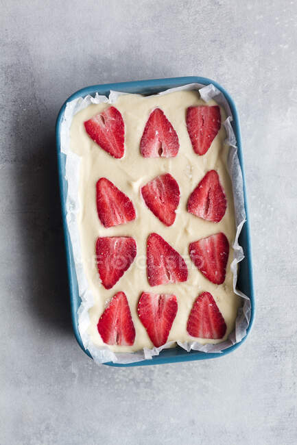 Vue du dessus de dessert sucré maison appétissant avec crème blanche et fraise fraîche tranchée sur fond de marbre — Photo de stock