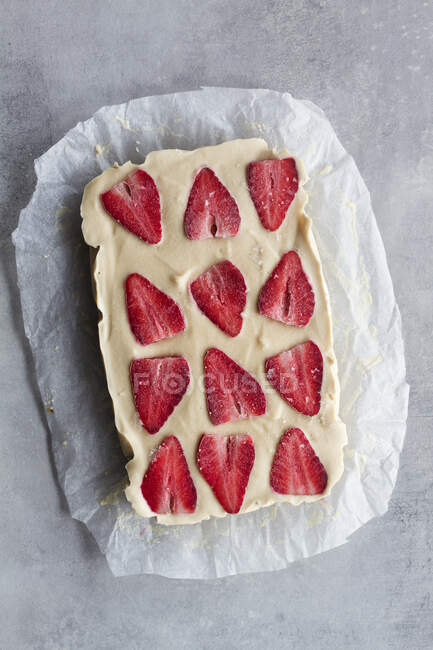 Draufsicht auf appetitliche hausgemachte süße Nachspeise mit weißer Sahne und in Scheiben geschnittenen frischen Erdbeeren auf Marmorhintergrund — Stockfoto