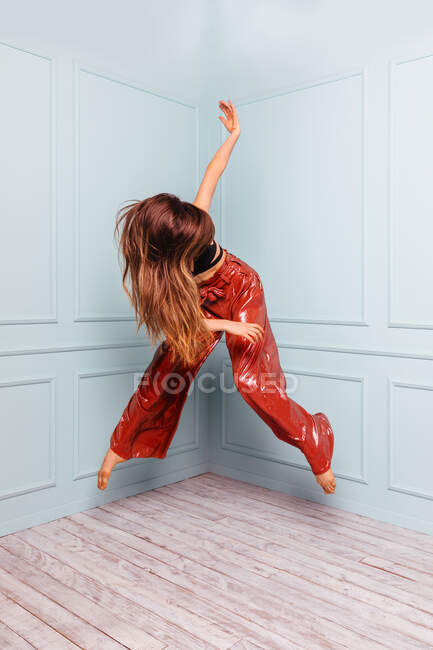Anonymous stylish dancer jumping in corner of studio — Stock Photo