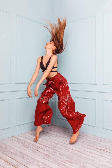 Elegante bailarina saltando en la esquina del estudio - foto de stock
