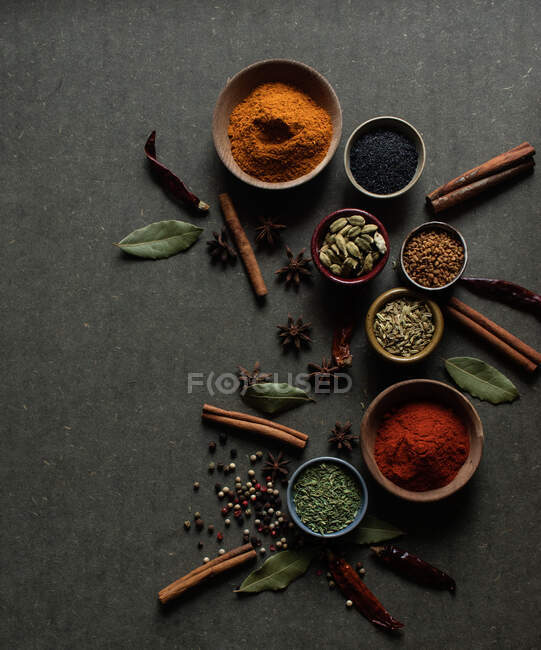 Zusammensetzung von oben mit verschiedenen Arten natürlicher aromatischer Gewürze auf dunkelgrauem Hintergrund — Stockfoto