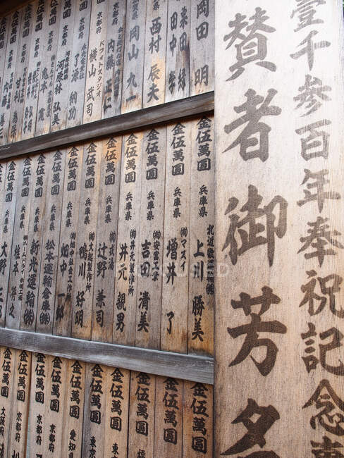 Pared de madera con kanji cerca del templo - foto de stock