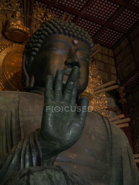 D'en bas sculpture de Bouddha situé contre le mur ornemental dans le vieux temple asiatique au Japon — Photo de stock