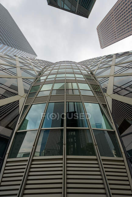 Torre de vidro moderno sob céu nublado — Fotografia de Stock