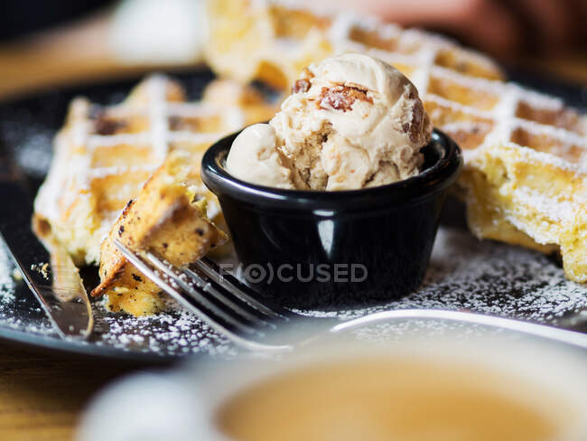 Вид сверху на миску с мячом мороженого, выложенным на тарелку возле сладкого мягкого пирога в кафе — стоковое фото
