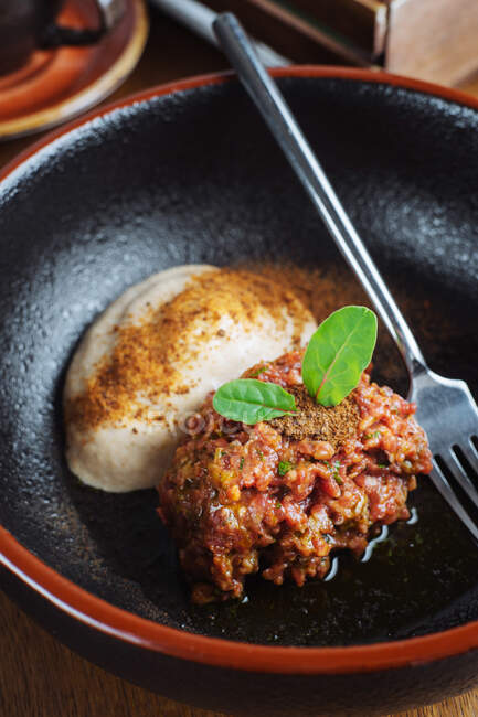Dall'alto deliziosa carne macinata fritta con spinaci e salsa alla panna posta in ciotola nera — Foto stock