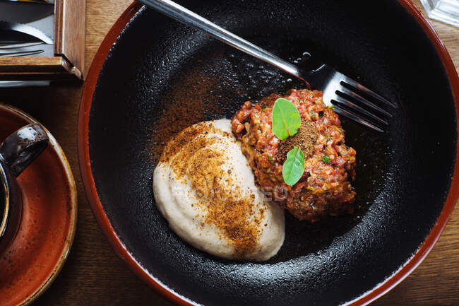 Зверху смачне смажене м'ясо зі шпинатом та вершковим соусом, розміщеним у чорній мисці — стокове фото