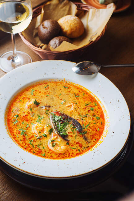 De arriba de la sopa apetitosa aromática de tomate con las setas porcini y las hierbas verdes servidas en el plato blanco - foto de stock