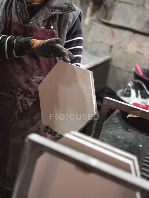 Прокоп самець в фартусі і рукавички, що тримають шестикутну свіжу плитку з сировиною — стокове фото