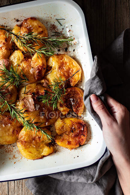 From above crop anonymous person hands holding hot white plate with napkin delicious fried shrimp served on with fresh rosemary and salt flakes — Stock Photo