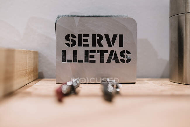 Porta tovaglioli in metallo con scritta Servilletas intagliata posta sul tavolo in una moderna caffetteria in Navarra, Spagna — Foto stock