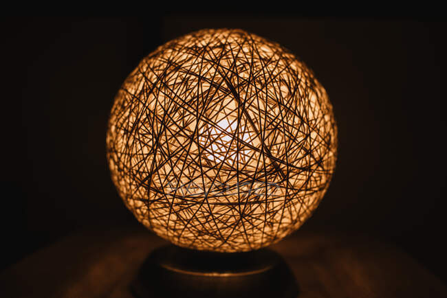 Lampe à la main tendance de forme ronde placée sur une table dans une pièce sombre en Navarre, Espagne — Photo de stock