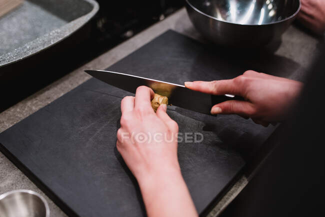 Crop person cutting chicken breast — Stock Photo
