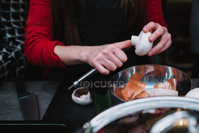 Unrecognizable female cleaning and mushroom over metal bowl during cooking course in restaurant kitchen in Navarre, Spain — Stock Photo
