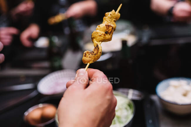 Unrecognizable person enjoying delicious chicken skewers during dinner after lesson in cooking workshop in Navarre, Spain — Stock Photo