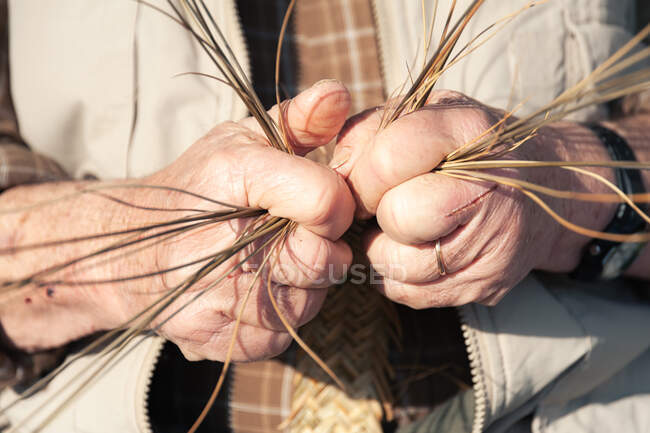 Пожилой ремесленник, создающий плетеную — стоковое фото