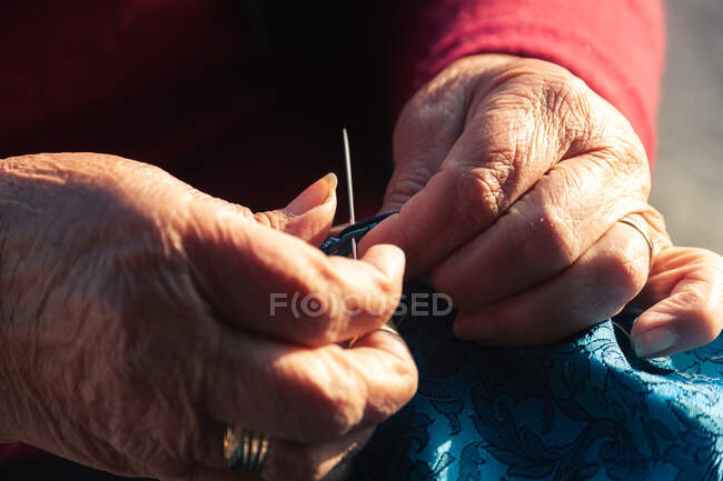 Crop idoso artesanato fazendo cachecol — Fotografia de Stock
