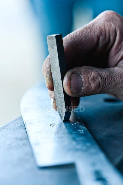 Senior smith decorating steel knife — Stock Photo